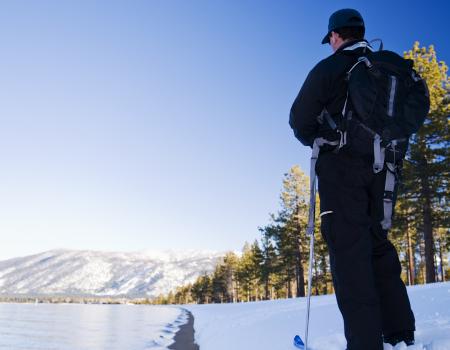 man standing still on skis looking at the snow